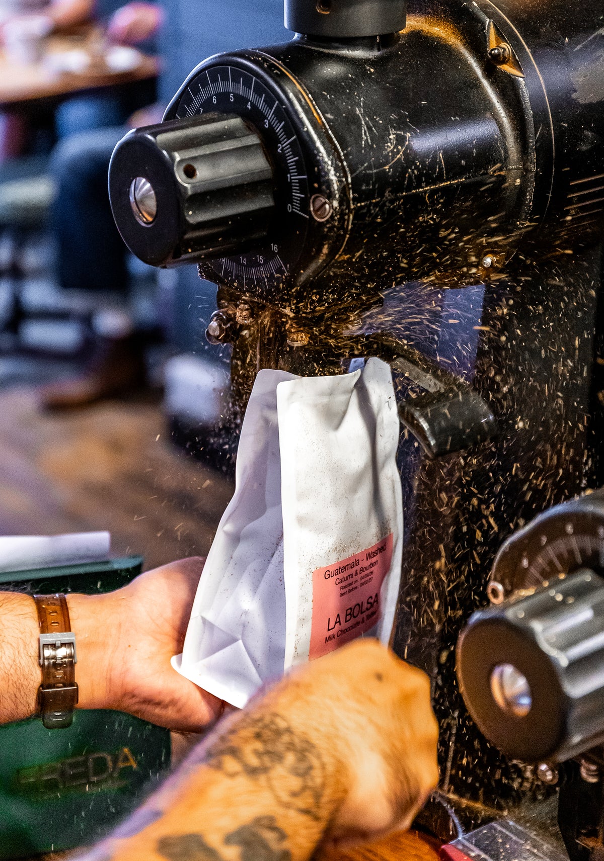 Coffee grinder action shot, coffee spraying everywhere in speciality coffee shop