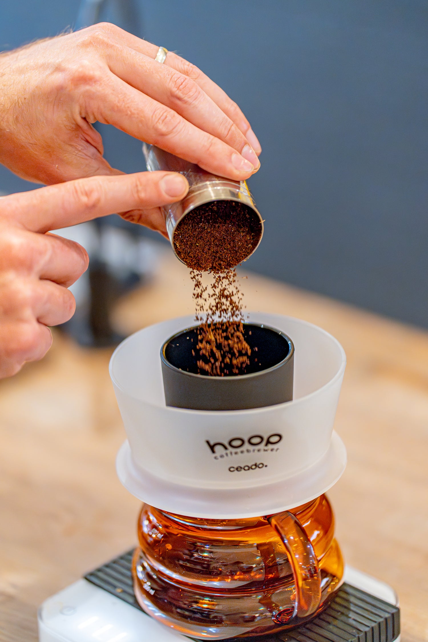 Adding freshly roasted coffee to the Cedar Hoop speciality coffee brewer